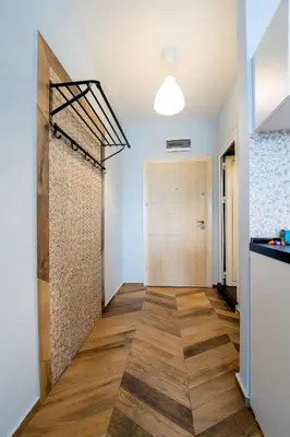 a hallway with a door and wood floors at Cozy little apartment in Studentski grad in Sofia