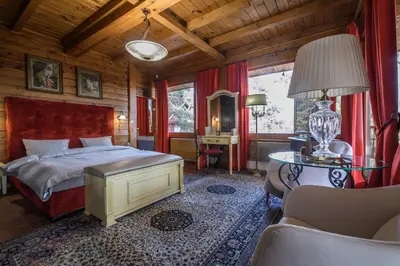 a bedroom with a bed and a table with a lamp at Villa Anna Luxury Lake Residence in Shtarkelovo Gnezdo