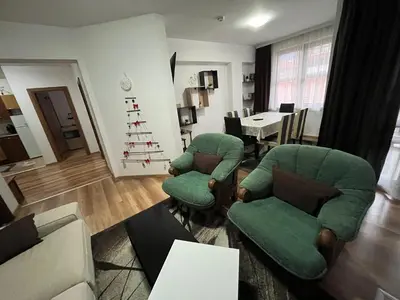 a living room with two chairs and a christmas tree at Marina Apartment in Bansko