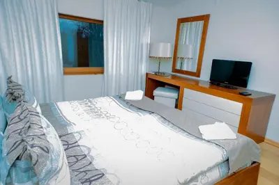 a bedroom with a bed and a desk and a mirror at Luxury houses in Dobrinishte in Dobrinishte