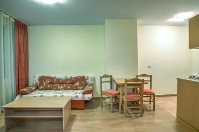 a living room with a couch and a table and chairs at Studio - Apartments Castle Complex 2 in Pamporovo