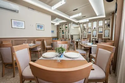a dining room with wooden tables and chairs at AquaSun Family Hotel in Sandanski