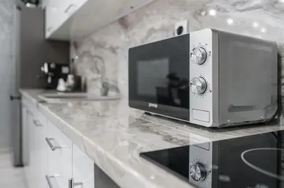 a microwave oven sitting on a counter in a kitchen at City Apartments - a brand new luxury & comfy 2 in Asenovgrad