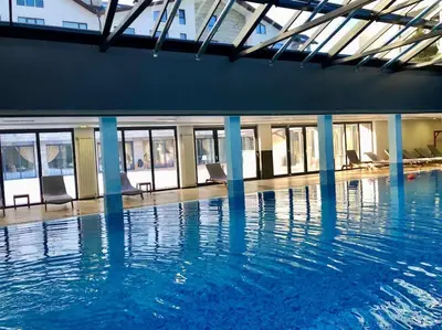 a large swimming pool with chairs in a building at LUXURY PENTHOUSE WITH A LAVISH SPA and 2 en-suite bedrooms in Bansko