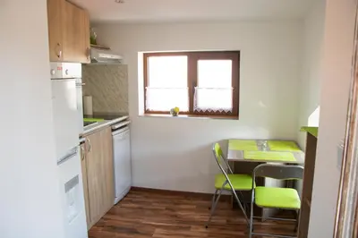 a small kitchen with a table and chairs and a window at ALBISTO Dragalevtsi Luxury Apartments in Sofia