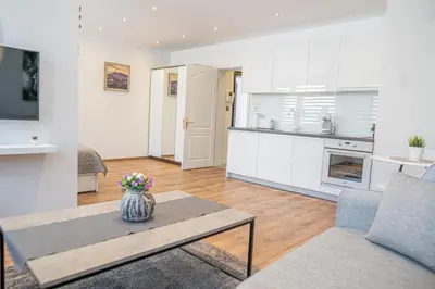 a living room with a table and a kitchen at Shushi's Central Studio Apartment in Plovdiv