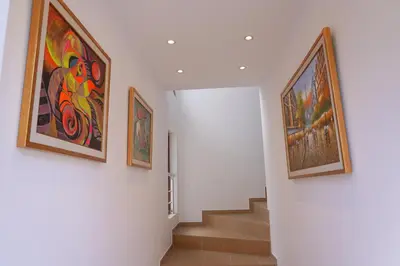 a hallway with paintings on the walls and stairs at Shushi's Central Studio Apartment in Plovdiv