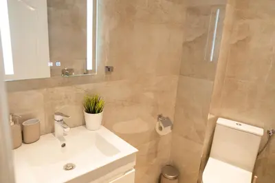 a bathroom with a sink and a toilet and a mirror at Shushi's Central Studio Apartment in Plovdiv