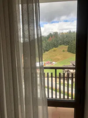 a window with a view of a green field at Апартамент Пампорово Палас - Pamporovo Palace in Pamporovo