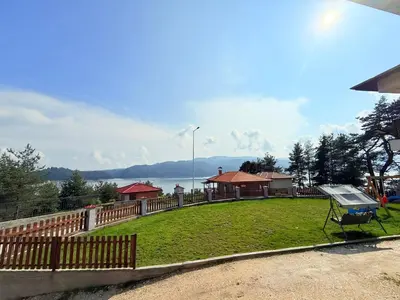 a park with a fence and a bench on the grass at Вила Слънчев Бряг in Dospat