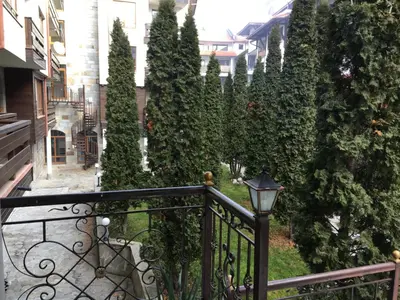 a fence next to a row of trees at 2 bedroom apartment near Gondola in Bansko