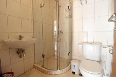 a bathroom with a shower and a toilet and a sink at 2 bedroom apartment near Gondola in Bansko