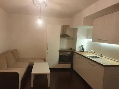 a small kitchen with a couch and a table at The white apartment at the ski in Bansko