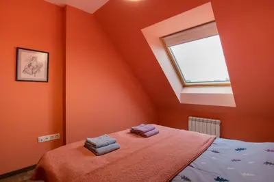 a bedroom with orange walls and a bed with two towels at Apartment City View 2 in Sofia