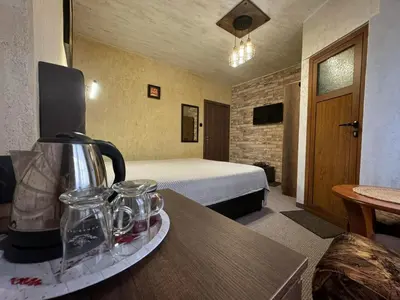 a hotel room with a bedroom with a bed at Guest House Ivan in Bansko