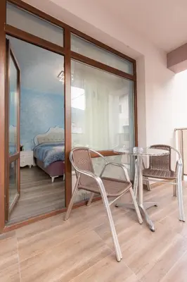 a room with a glass table and chairs and a bed at Къща за гости