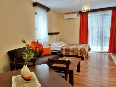 a living room with a couch and a table and a bed at Приказното място - The Fairytale Place in Smolyan