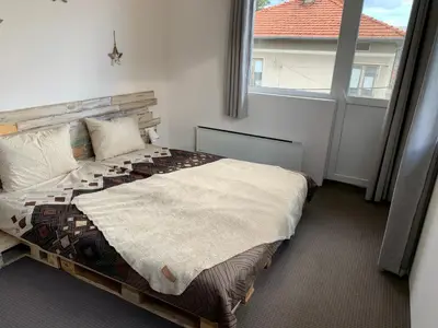 a bedroom with a bed and a large window at Апартамент “МИЛА” in Troyan