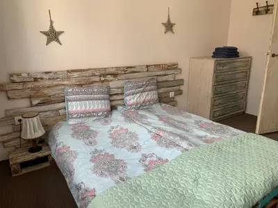a bedroom with a bed with a wooden headboard and pillows at Апартамент “МИЛА” in Troyan