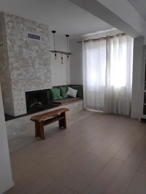 a living room with a couch and a fireplace at Апартамент “МИЛА” in Troyan