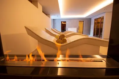 a bathtub in a room with fire in it at Hotel Malyovitsa in Govedartsi
