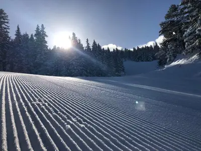 a snow covered field with the sun in the background at Hotel Malyovitsa in Govedartsi