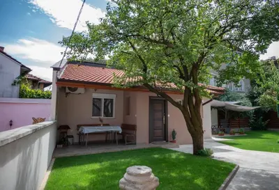 a small house with a tree in the yard at Къща за гости Фолис in Kyustendil