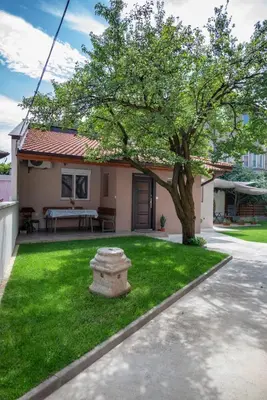 a small house with a tree in the yard at Къща за гости Фолис in Kyustendil