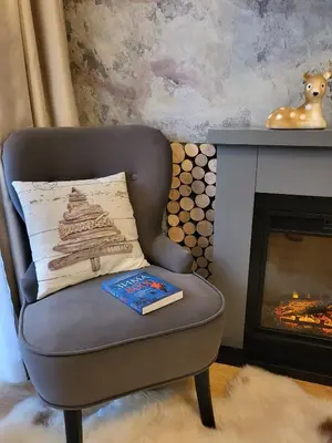 a book sitting on a chair with a fireplace at Pinewood ANG Apartment, Semiramida Borovets Hills in Borovets