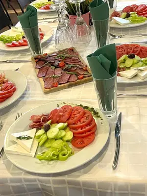 a white table with plates of food on it at Хотел Дива in Blagoevgrad
