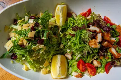 a salad in a white bowl with lemon slices at Хотел Дива in Blagoevgrad