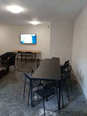 a meeting room with tables and chairs and a screen at Hostel Iliana Общежитие Илияна in Elin Pelin