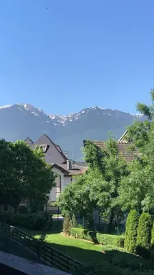a house with trees and mountains in the background at Aspen Valley in Razlog