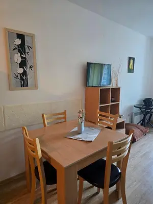 a dining room table with chairs and a television at Aspen Valley in Razlog