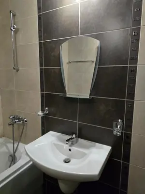 a bathroom with a sink and a mirror and a tub at Aspen Valley in Razlog