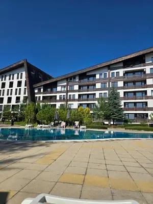 a building with a swimming pool in front of a building at Aspen Valley in Razlog