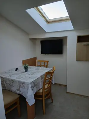 a dining room with a table with chairs and a skylight at Guest rooms Bansko in Bansko