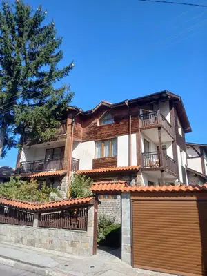 a large house with a garage in front of it at Guest rooms Bansko in Bansko