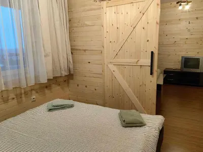 a bedroom with a bed and a wooden wall at Bansko Royal Towers - Studio 945 in Bansko