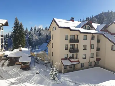 an apartment building with snow on the ground at апартамент Манастира 1 in Pamporovo