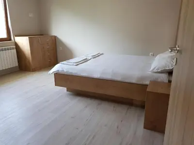 a bedroom with a bed and a wooden floor at Апартаменти Гювийски in Sapareva Banya