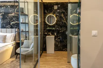 a room with glass doors and a chair in a room at Family Hotel The View & SPA in Tsigov Chark
