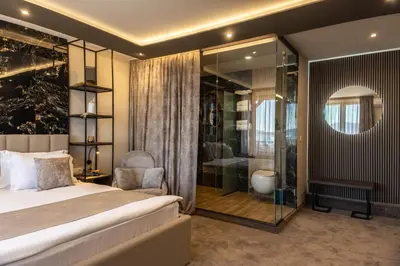 a bedroom with a bed and a bathroom with a shower at Family Hotel The View & SPA in Tsigov Chark