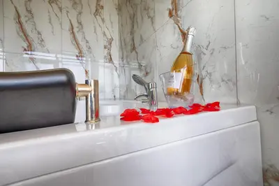 a bottle of wine sitting on top of a sink at Family Hotel The View & SPA in Tsigov Chark