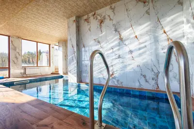 a swimming pool with metal stairs leading to a swimming pool at Family Hotel The View & SPA in Tsigov Chark