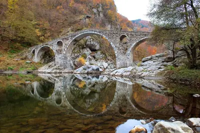 an old stone bridge over a body of water at Stylish loft studio with great view to Ardino in Ardino