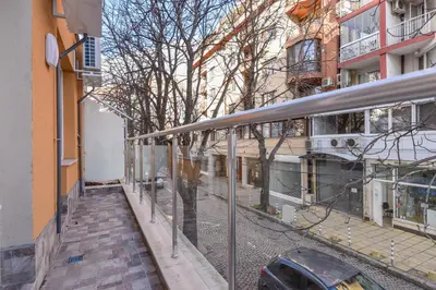 a building with a glass walkway next to a street at Stylish Residential Flat - with Parking & Balcony by Flat Mаnager in Sofia