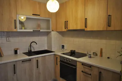 a kitchen with wooden cabinets and a sink and a stove at New Apartment at a Great Location in Blagoevgrad