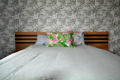 a bed with two pillows on it with a wallpaper at New Apartment at a Great Location in Blagoevgrad