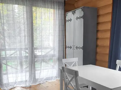 a table and chairs in a room with a window at Власовъ in Pamporovo